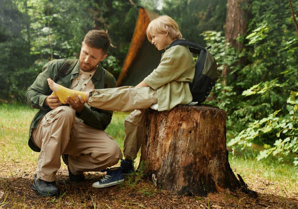 man taping ankle on boy at camp